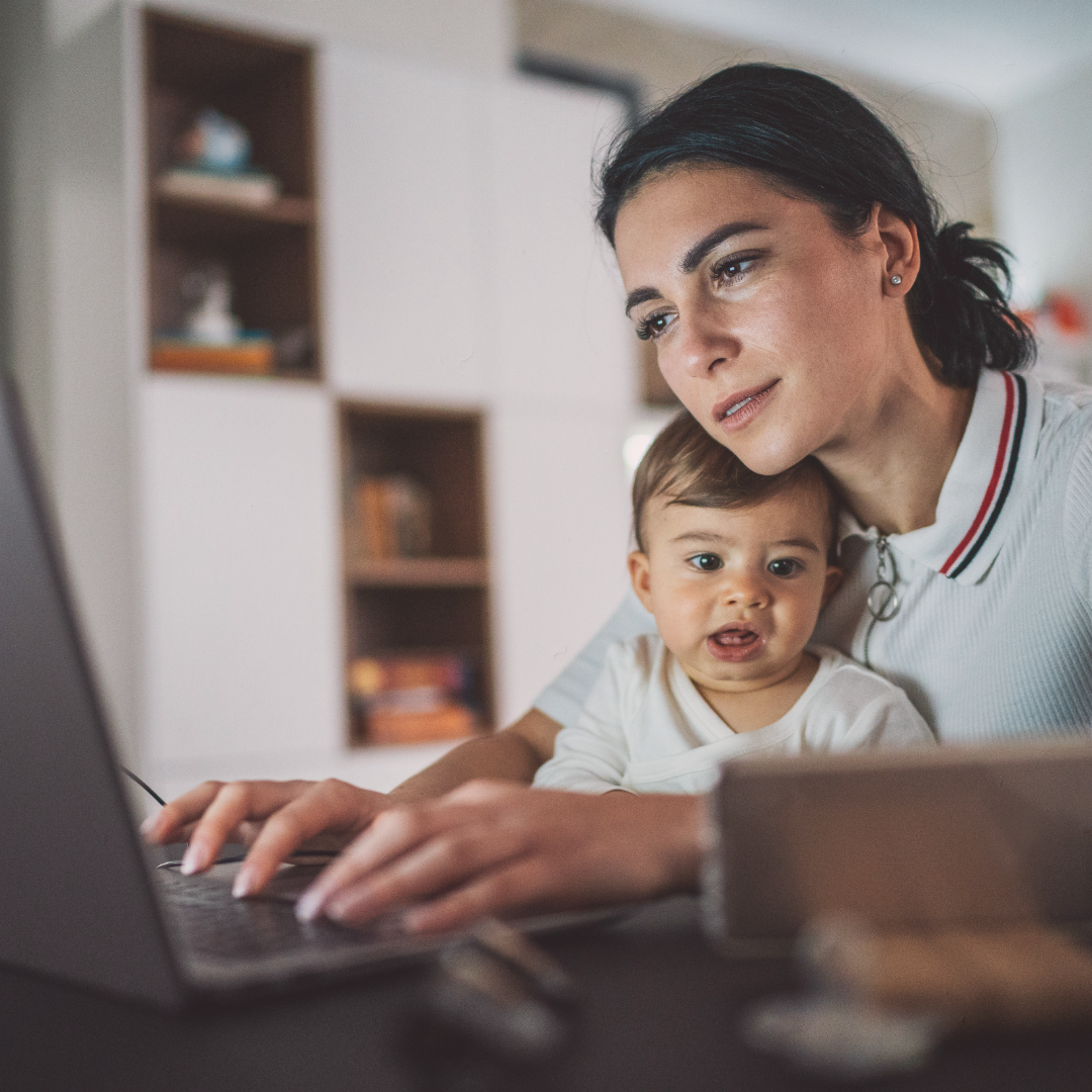 Mother working with baby on her lap