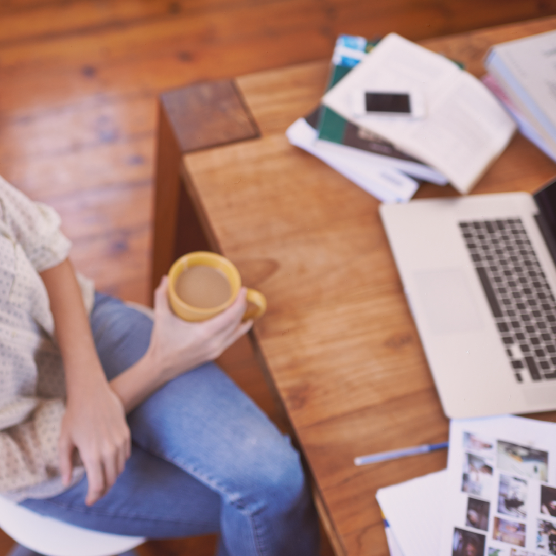 Overhead view of a woman working at her desk with coffee